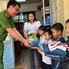 Trung tá Nguyễn Hồng Kiên (phải) cùng các mạnh thường quân tặng đồ cho học sinh Trường Tiểu học Bi Năng Tắc. Ảnh: VŨ LONG