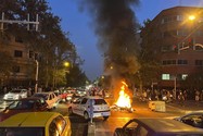 Người biểu tình đốt cháy xe cảnh sát Iran tại thủ đô Tehran (Iran) ngày 19-9. Ảnh: AP