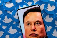 Tỉ phú Elon Musk cùng các logo Twitter. Ảnh: REUTERS