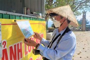 Anh Huỳnh Ngọc Lĩnh xem lại những tấm ảnh cũ trong lúc chờ khách.