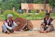 Già Rơ Châm Hyai, làng Mít Jép, xã Ia O (phải), đan áo cho chiêng. Ảnh: TD