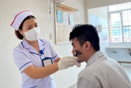 Điều dưỡng Nguyễn Thị Xuân cạo râu cho một nam bệnh nhân tâm thần. Ảnh: TRẦN NGỌC