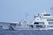 Tàu dân quân trên biển của Trung Quốc áp sát tàu của Lực lượng Bảo vệ bờ biển Philippines trên Biển Đông. Ảnh: AP