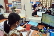 Cán bộ UBND quận Tân Bình (TP.HCM) đang hỗ trợ người dân sao y sổ hộ khẩu. Ảnh: HUỲNH THƠ