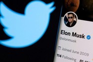 Tài khoản Twitter của tỉ phú Elon Musk được nhìn thấy trên điện thoại thông minh phía trước logo Twitter.