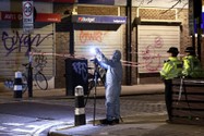 Nhân viên pháp y làm việc tại hiện trường vụ nổ súng xảy gần Nhà thờ St Aloysius, ở thủ đô London (Anh) ngày 14-1. Ảnh: REUTERS