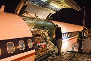 Công nhân bốc dỡ hàng viện trợ do Iran gửi tới tại sân bay ở TP Aleppo, phía bắc Syria vào sáng sớm ngày 8-2. Ảnh: AFP