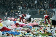 Các cầu thủ nhặt những chú gấu bông mà người hâm mộ quyên góp cho trẻ em vùng động đất ở Thổ Nhĩ Kỳ. Ảnh: THE GUARDIAN