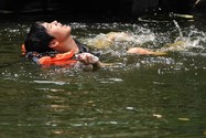 Một người đàn ông bơi trong một con kênh ở Bangkok (Thái Lan) ngày 22-4 khi nhiệt độ lên mức kỷ lục 45,4°C. Ảnh: REUTERS