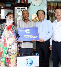 Phó Chủ tịch UBND TP.HCM Võ Văn Hoan (thứ hai từ trái) và Tổng biên tập báo Pháp Luật TP.HCM Mai Ngọc Phước (thứ ba từ phải) trao quà cho bà con ngư dân huyện Cần Giờ ngày 17-5.